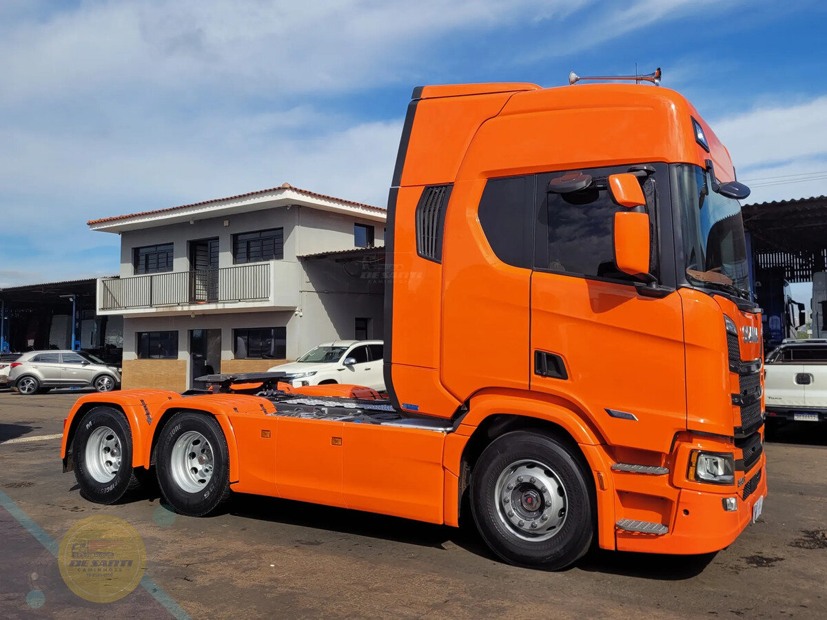 Scania R 560 Super 6x4 laranja - Vista lateral da tração 6x4